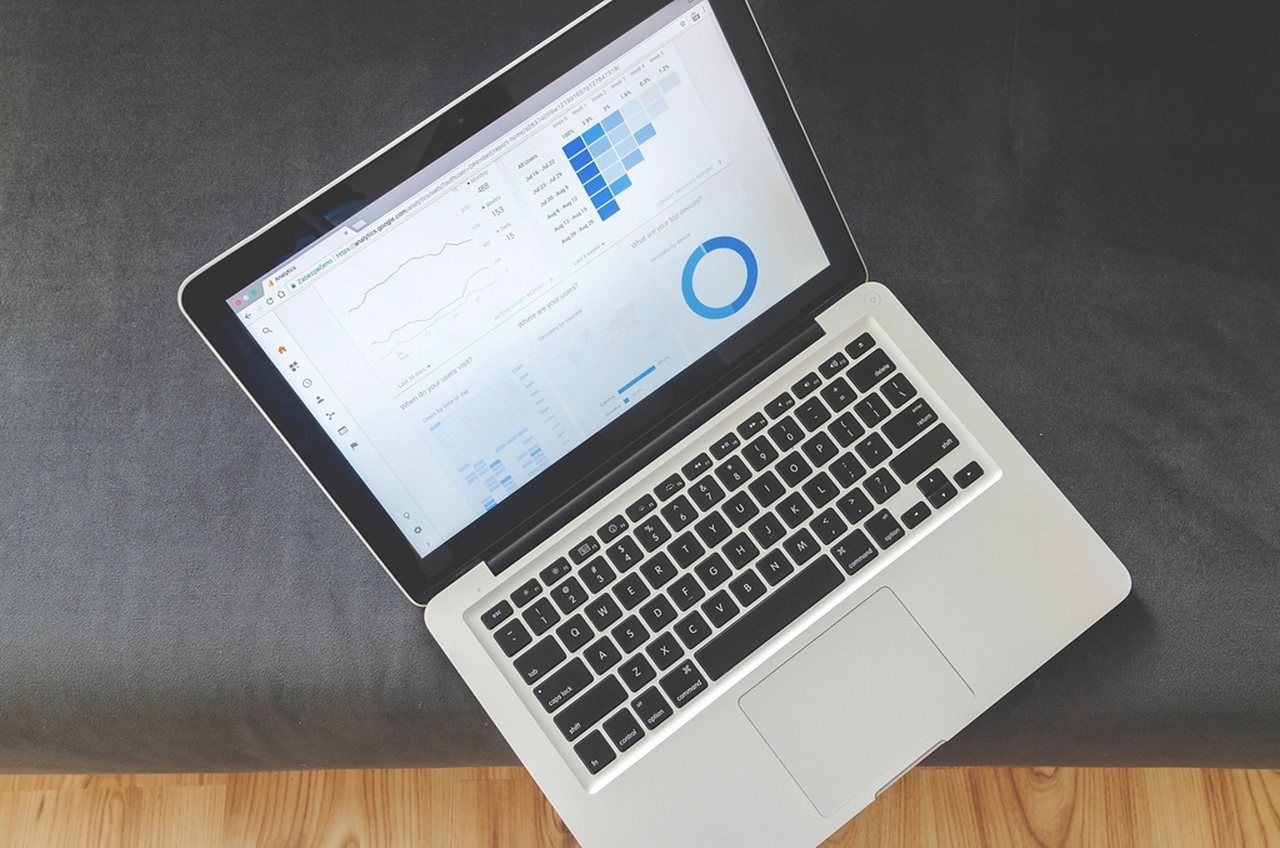 Aufgeklappter Laptop mit Diagrammen auf einem dunklen Tisch