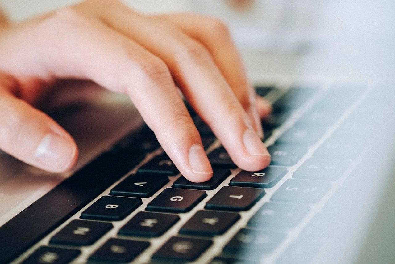 Hände tippen auf der Tastatur eines Laptops